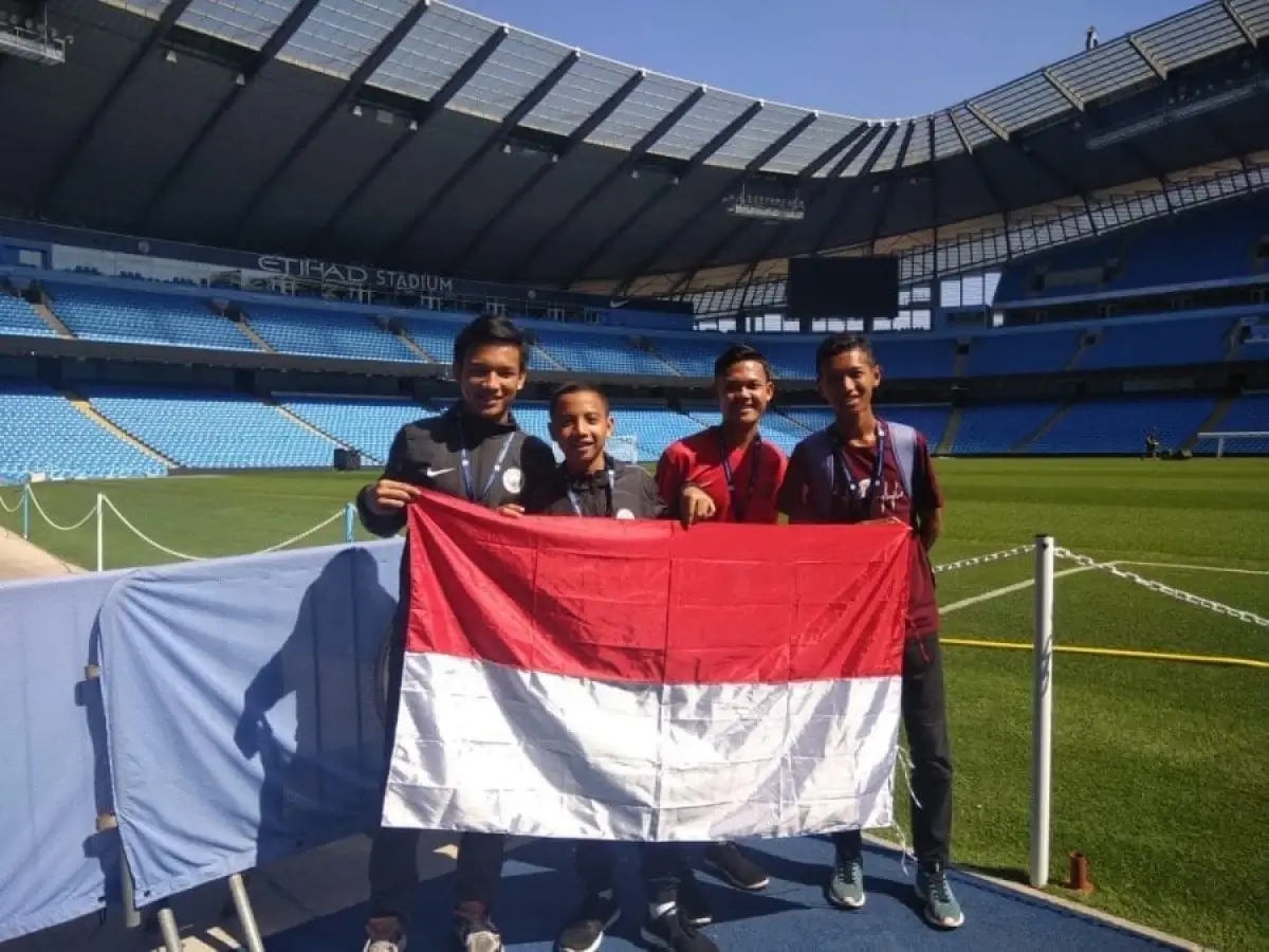 20 Kids From Around The World Had Fun Learning English And Football At Manchester City’s Etihad Campus 3 QNET Indonesia manchester city kids posing on stadium field