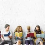people sitting together reading a book