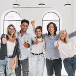 Group of young men and women in office giving thumbs up
