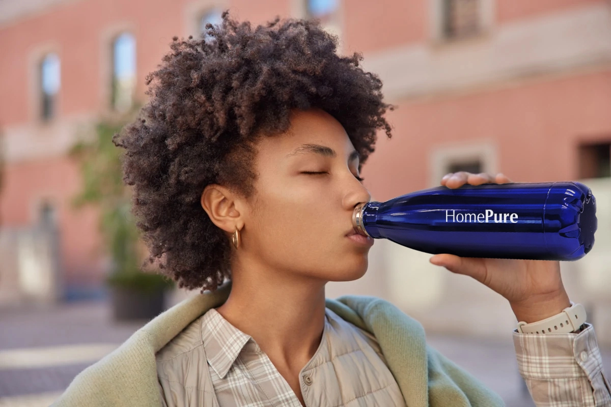 QNET Independent Distributor drinking from a HomePure bottle 