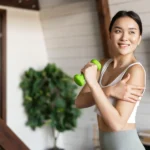 Woman exercising with a small dumbbell, reaping the benefits of a plant-based diet, which includes easing climate change effects