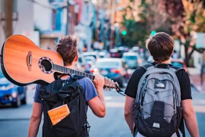 Two boys, one holding a guitar, on their way to enjoy the long weekend with a quick vacation via QVI Breaks