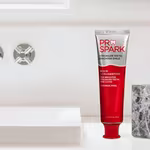 ProSpark toothpaste and wooden toothbrushes in a holder beside a bathroom sink