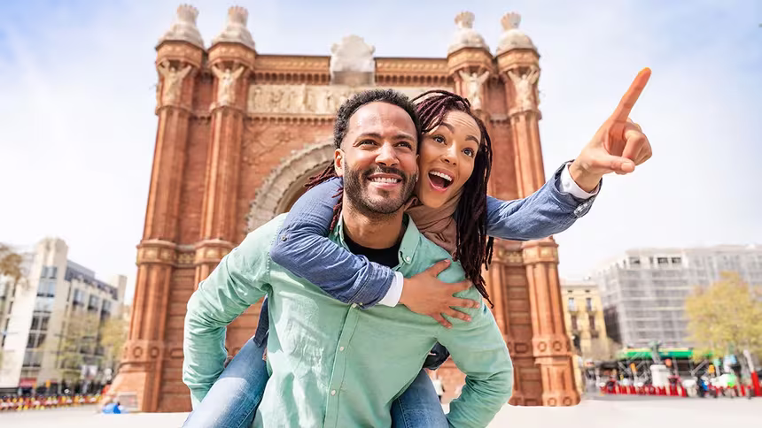 Man giving woman a piggy back ride in Europe while on a trip booked through a QVI holiday membership