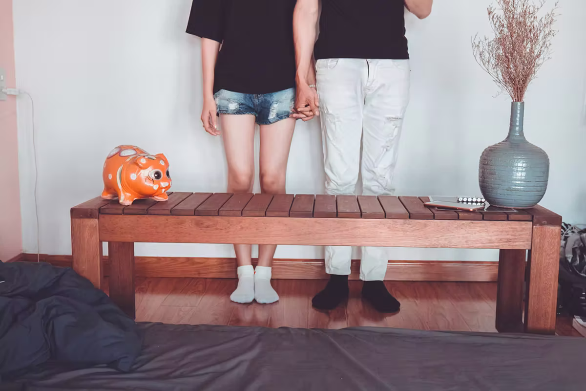 Couple holding hands in front of their furniture which they bought from wisely managing their QNET earnings